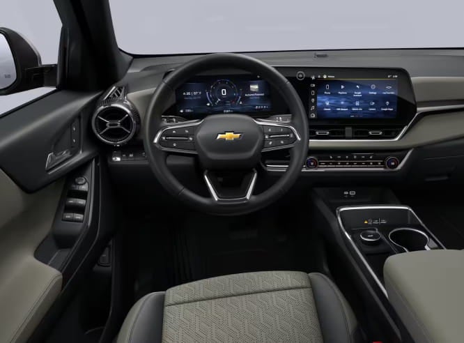 Front interior view of the Chevrolet Equinox featuring a digital instrument cluster, infotainment touchscreen, multifunction steering wheel, circular air vents, and a center console with cup holders.