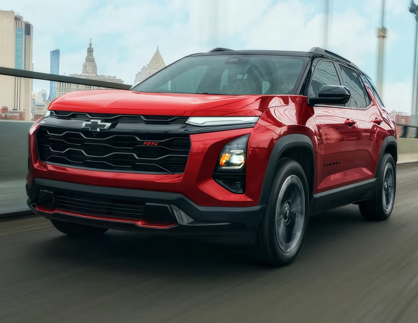 Red Chevrolet Equinox RS driving through a city.